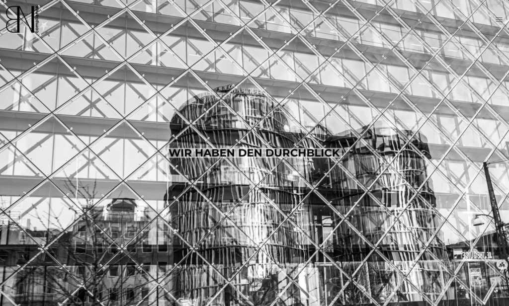 Modernes Gebäude mit reflektierender Glasfassade und Text "WIR HABEN DEN DURCHBLICK".