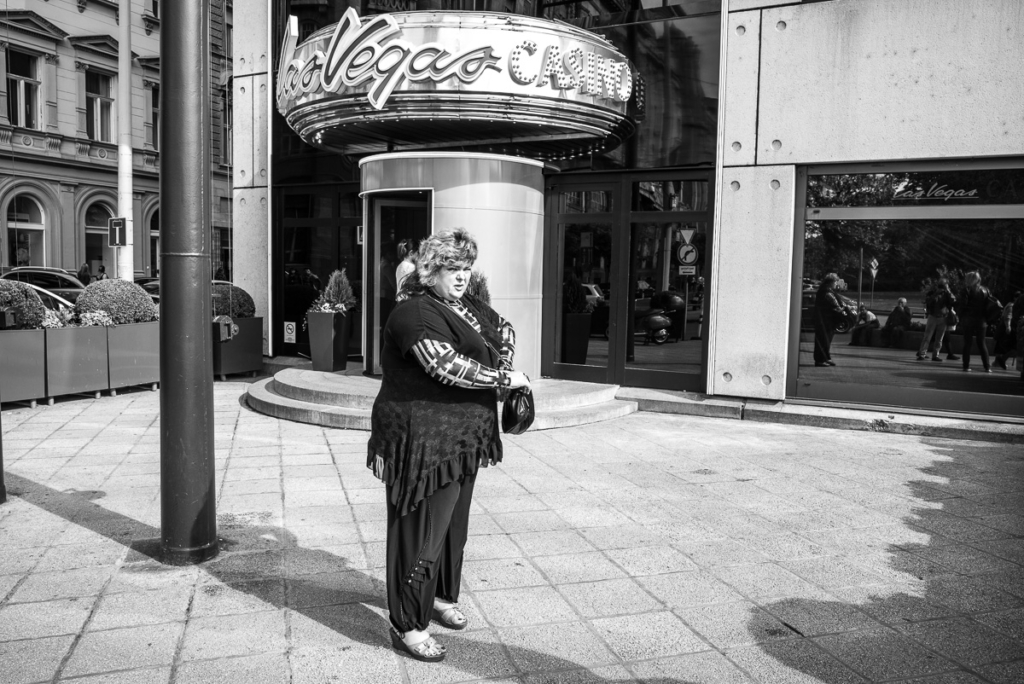 Frau auf Bürgersteig vor einem Gebäude mit "Las Vegas Casino"-Schild in Schwarz-Weiß.