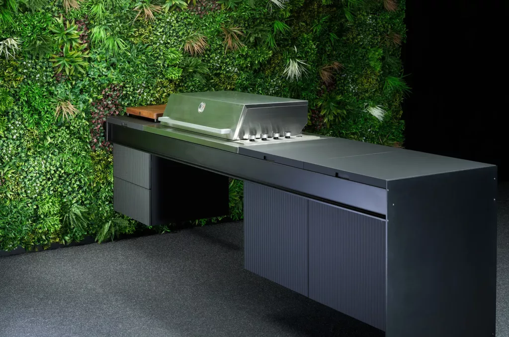 Moderner Grill vor Wand mit vertikalem Garten und üppigen grünen Pflanzen, Edelstahl-Design.