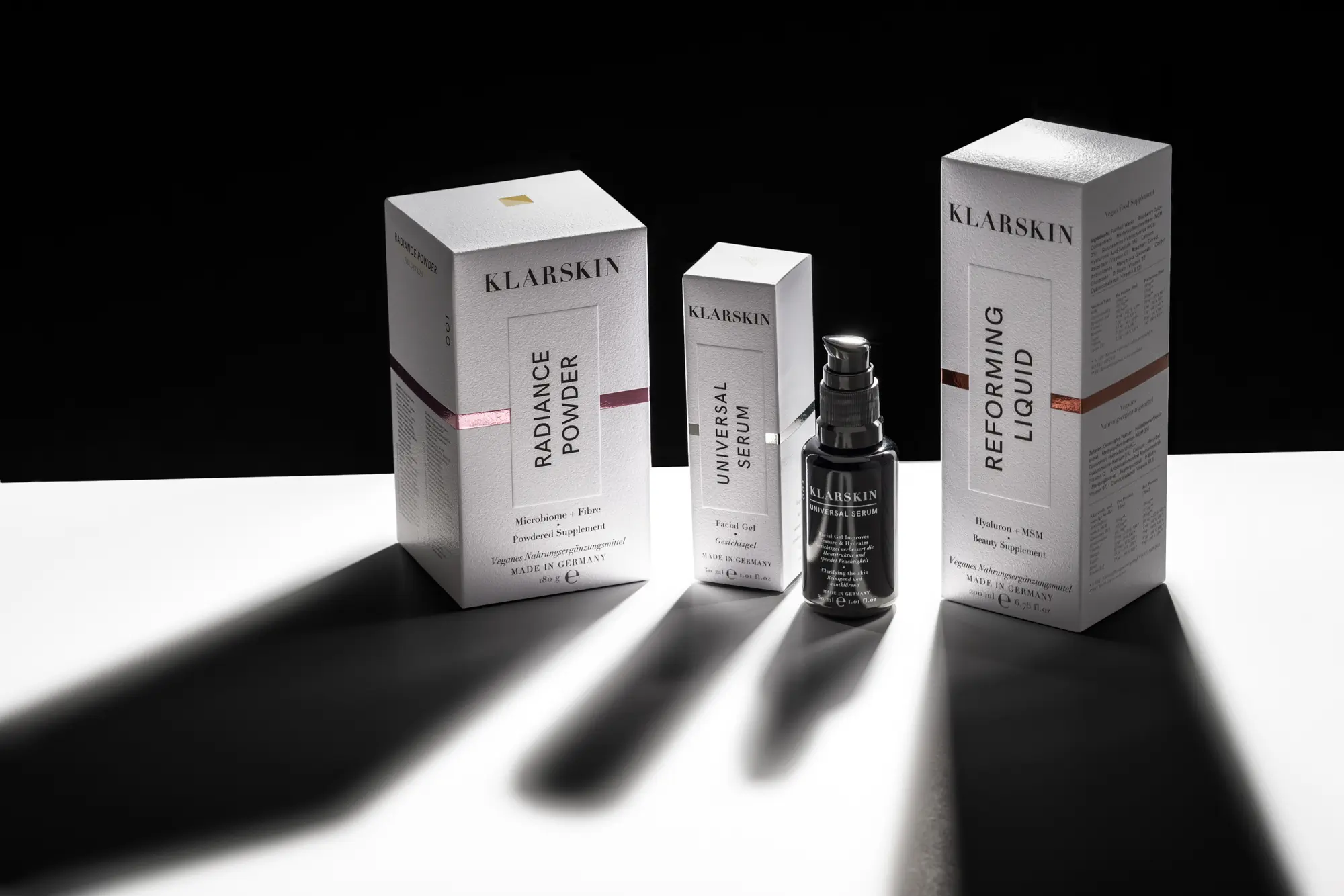 Radiance Powder, Universal Serum, Reforming Liquid in weißen Verpackungen mit Inhaltsangaben.