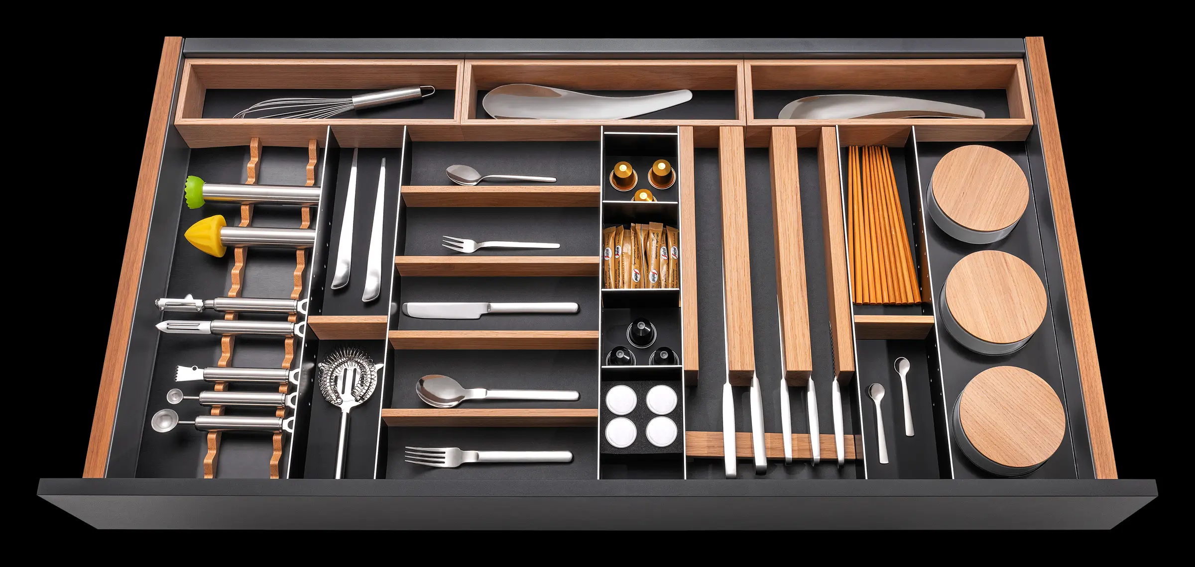 Schublade mit Besteckkasten, Utensilien und Fächern für Gewürze, Kapseln und Stäbchen.