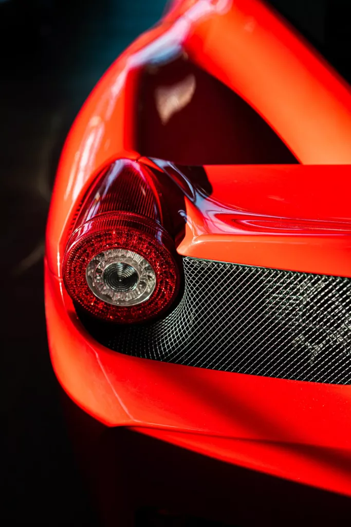 Rotes Sportwagen-Heck, Rundscheinwerfer, Gitternetzstruktur im Detail.