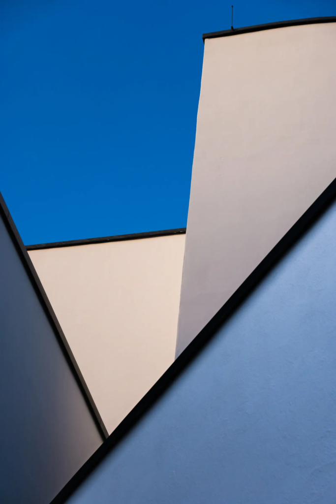 Geometrische Gebäudeformen mit klaren Linien vor blauem Himmel