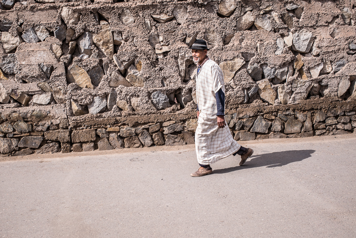Uniformierter Wachposten vor historischer Kulisse mit Personen und Skulpturen im Hintergrund.