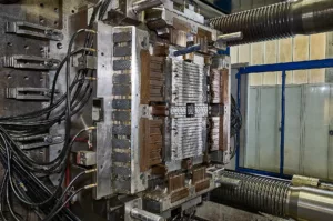 Industrielle Metallpresse mit komplexen mechanischen Komponenten und diversen Kabelanschlüssen.