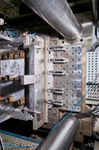 Industrieller Metallblock mit Bolzen, Hebeln, Kabeln und Bohrungen, komplexe Maschinenvorrichtung.