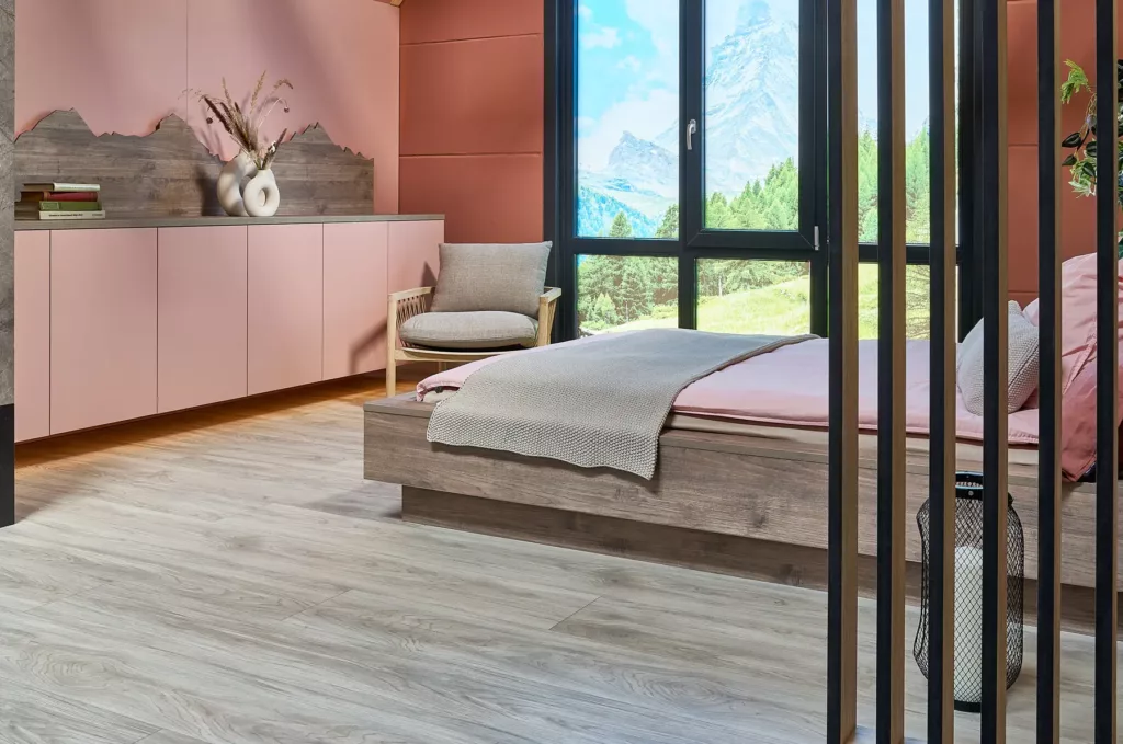 Modernes Schlafzimmer mit Holzbett, rosa Wänden, großem Fenster und Bergblick.