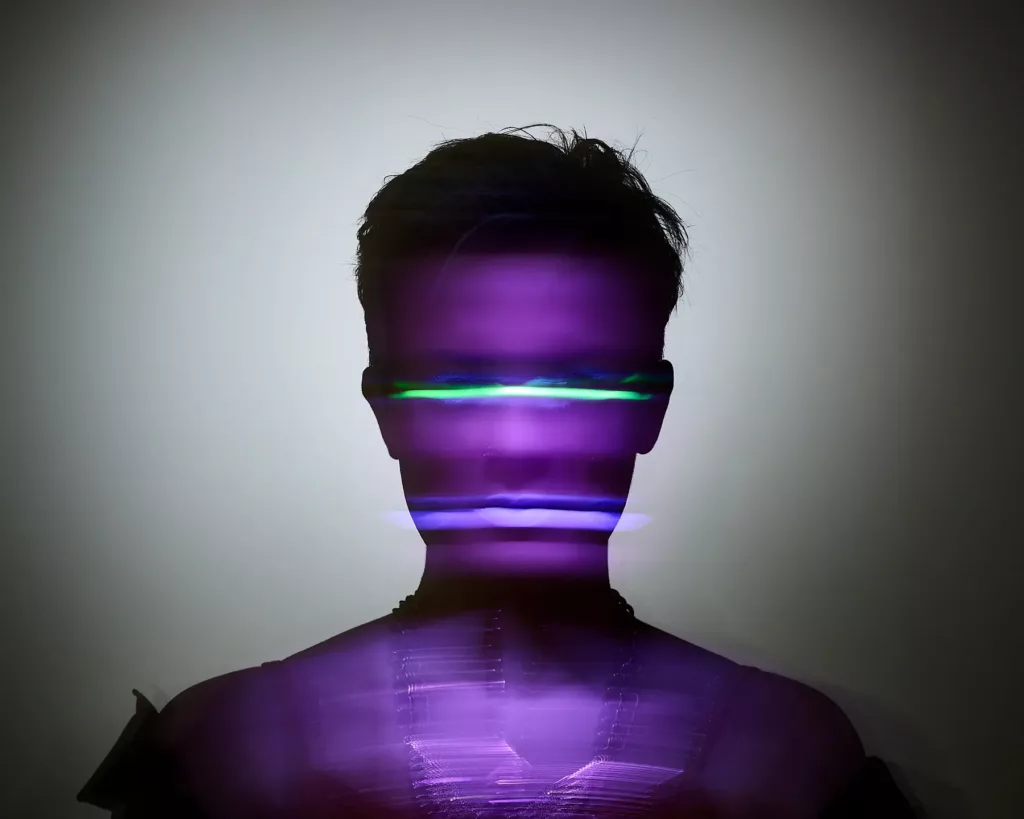 Silhouette einer Person mit violett-grünen Lichteffekten, abstrakt und futuristisch dargestellt.