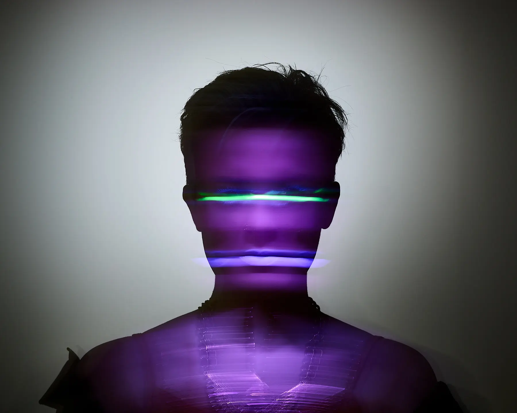 Silhouette einer Person mit violett-grünen Lichteffekten, abstrakt und futuristisch dargestellt.